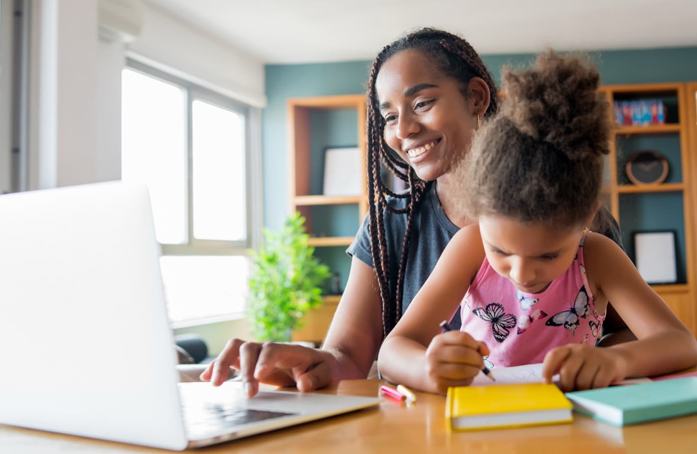 A mother and daughter homeschooling together on a laptop