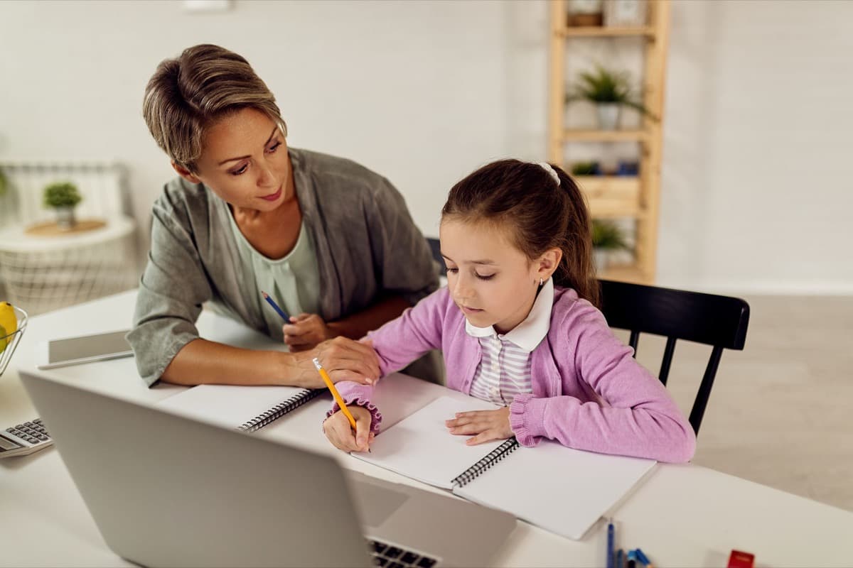 A mother helping her daughter with schoolwork