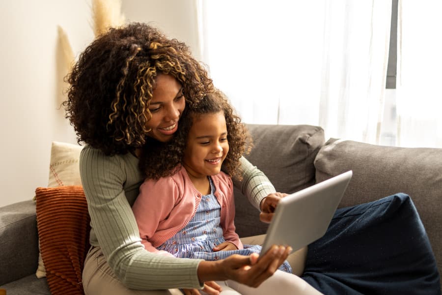 A parent and child using a tablet together at home