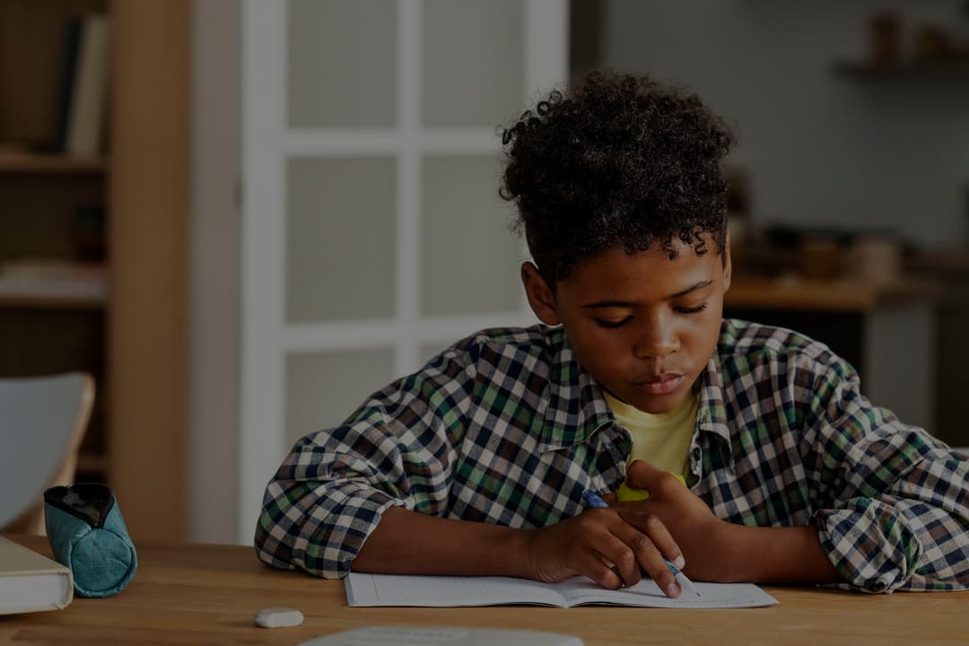 A boy writing at his desk